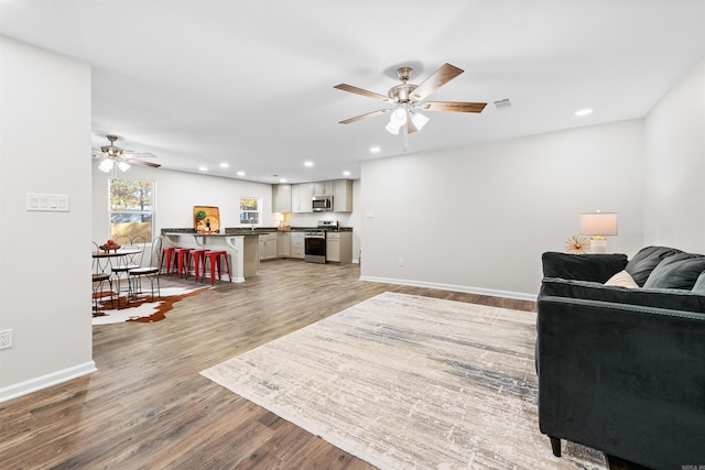 living room featuring ceiling fan and light wood-type flooring