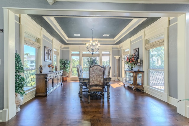 dining room featuring ornamental molding, a tray ceiling, an inviting chandelier, and dark wood-type flooring