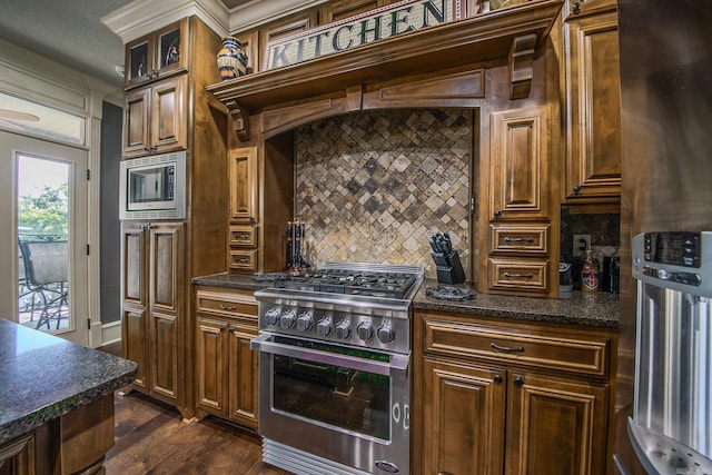 kitchen with a textured ceiling, dark hardwood / wood-style flooring, stainless steel appliances, and tasteful backsplash