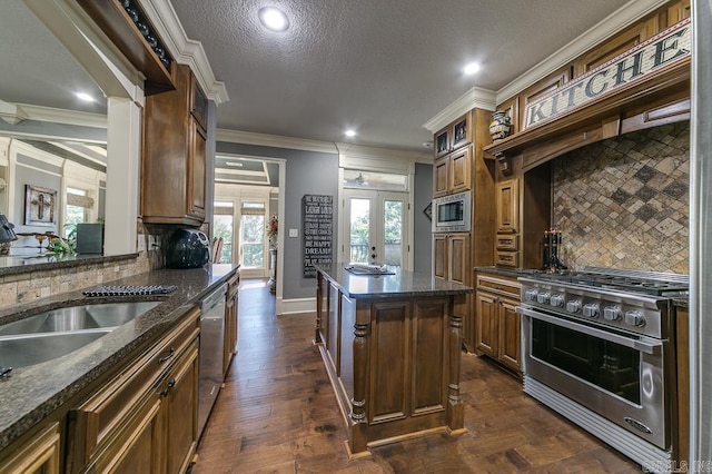 kitchen featuring backsplash, french doors, crown molding, appliances with stainless steel finishes, and a kitchen island