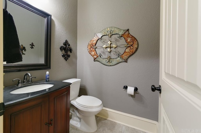 bathroom with tile patterned flooring, vanity, and toilet