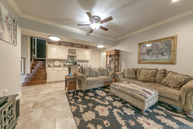 living room featuring ceiling fan, ornamental molding, and bar area