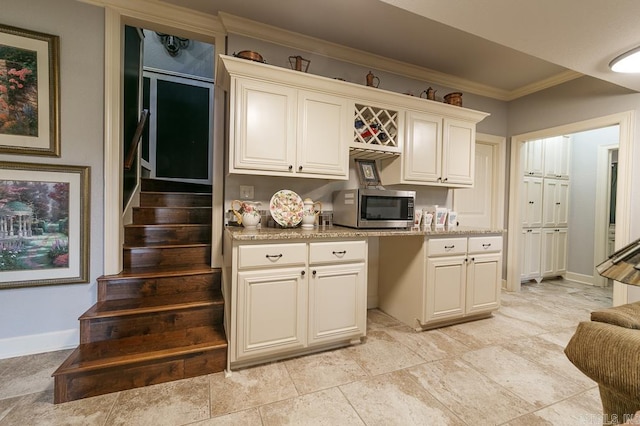 kitchen with light stone counters and crown molding