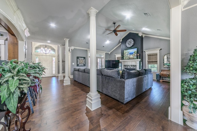 living room featuring vaulted ceiling, ceiling fan, ornamental molding, ornate columns, and dark hardwood / wood-style flooring