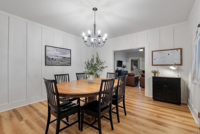 dining area featuring crown molding, ceiling fan with notable chandelier, and light wood-type flooring