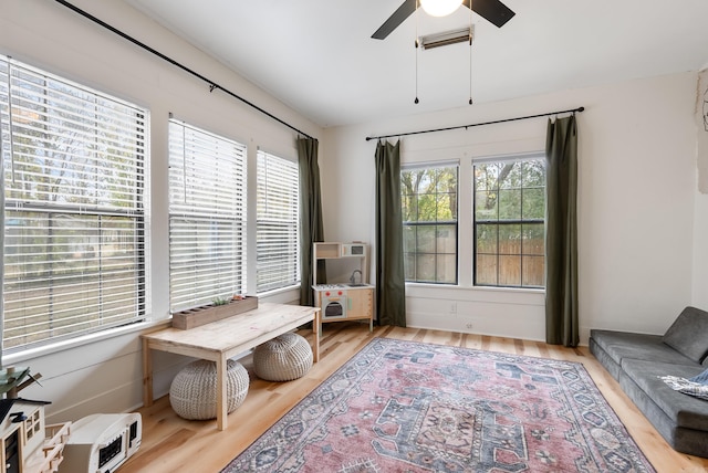 sitting room featuring light hardwood / wood-style floors, ceiling fan, and a healthy amount of sunlight