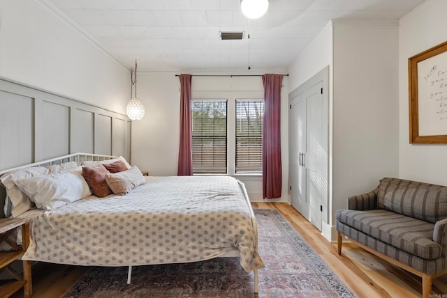 bedroom featuring wood-type flooring and ornamental molding