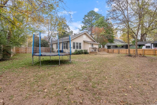 view of yard with a wooden deck and a trampoline