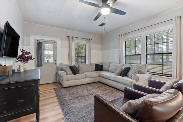 living room featuring light hardwood / wood-style floors, crown molding, and a wealth of natural light