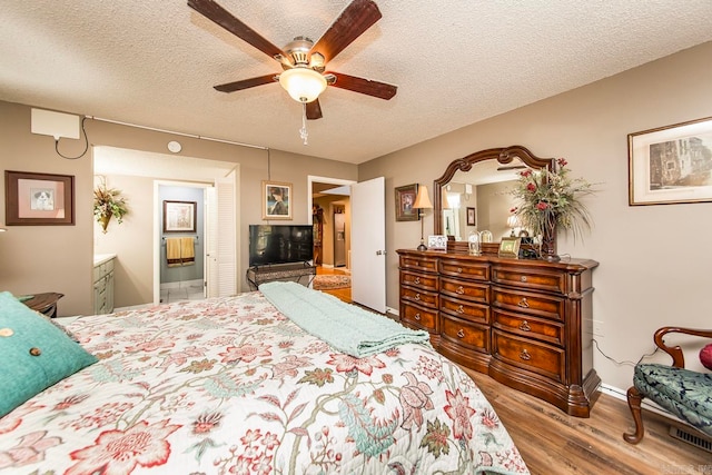 bedroom featuring connected bathroom, ceiling fan, a textured ceiling, and light wood-type flooring