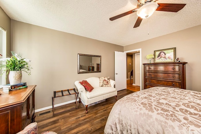 bedroom featuring a textured ceiling, dark hardwood / wood-style flooring, and ceiling fan