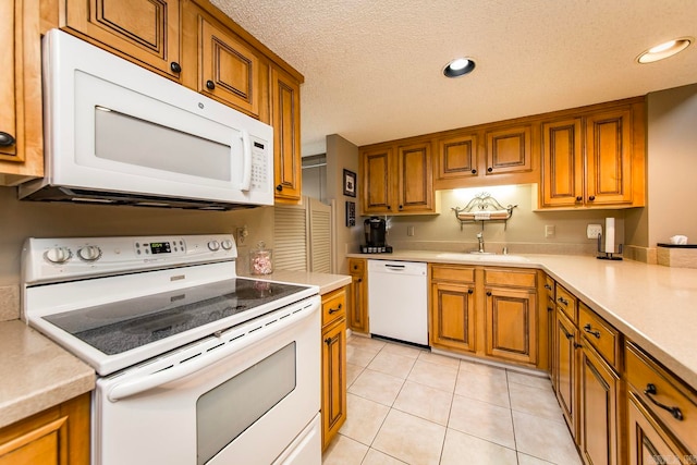 kitchen featuring light tile patterned flooring, sink, white appliances, and a textured ceiling