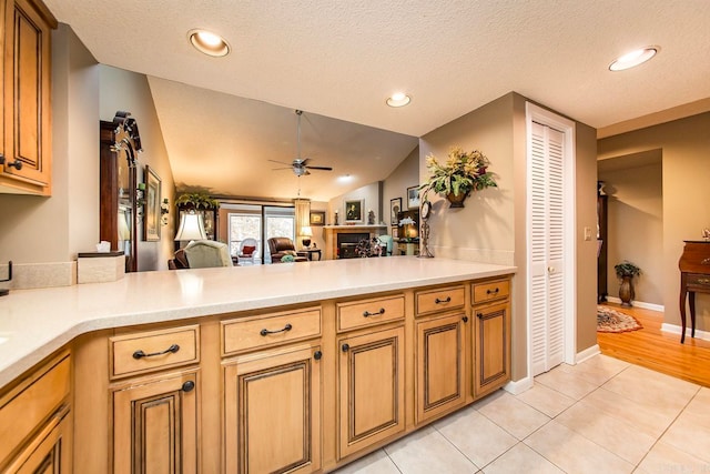 kitchen featuring a textured ceiling, light tile patterned flooring, and lofted ceiling