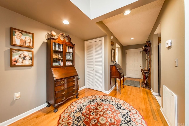 hallway with light hardwood / wood-style floors