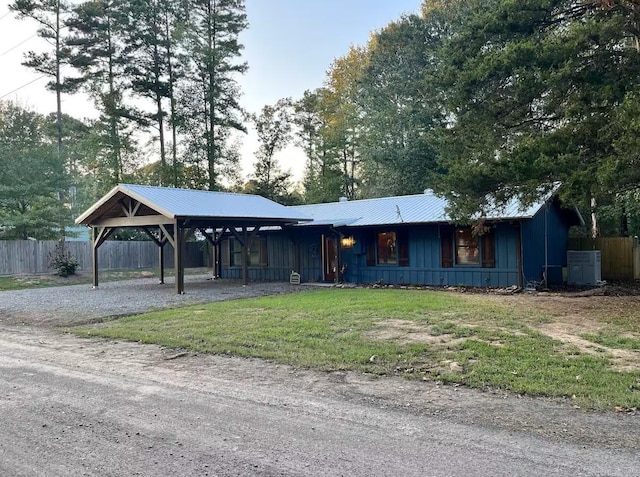 ranch-style house with a front yard, a carport, and central air condition unit