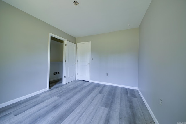 unfurnished bedroom featuring a closet and light hardwood / wood-style floors