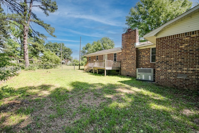 view of yard featuring central air condition unit and a wooden deck