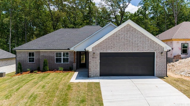 view of front of property featuring a garage, central air condition unit, and a front yard