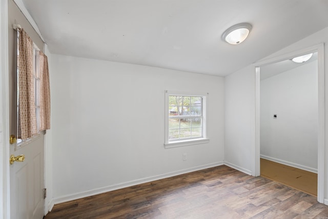 unfurnished room with dark hardwood / wood-style floors and lofted ceiling