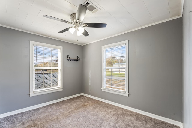 empty room with ceiling fan, a healthy amount of sunlight, carpet floors, and crown molding