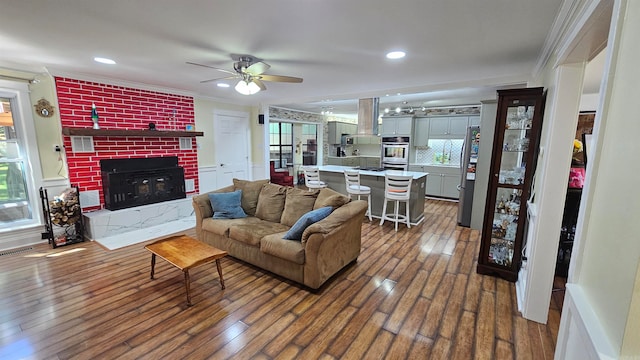 living room with ceiling fan, ornamental molding, and dark hardwood / wood-style floors