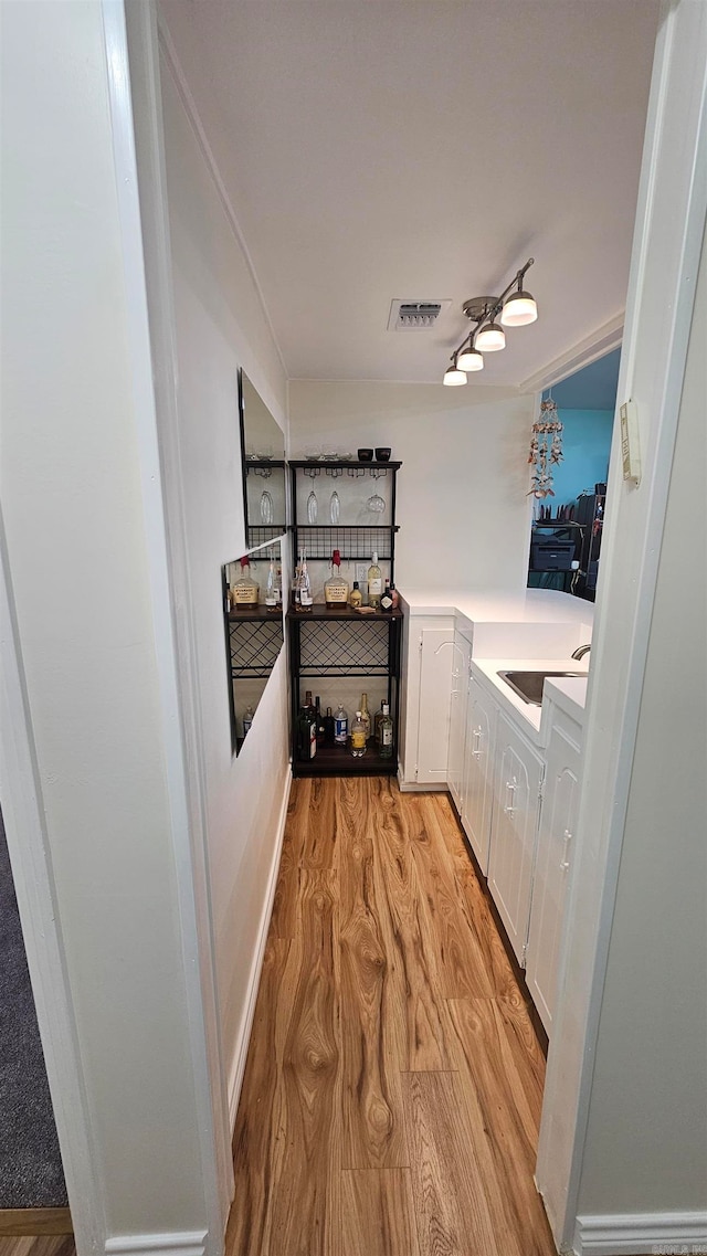 interior space featuring sink, white cabinets, and light hardwood / wood-style flooring