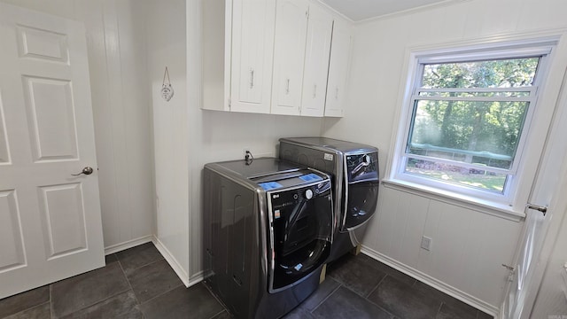 clothes washing area featuring cabinets, ornamental molding, and independent washer and dryer