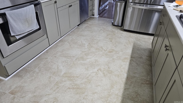 kitchen featuring fridge, range, and gray cabinets