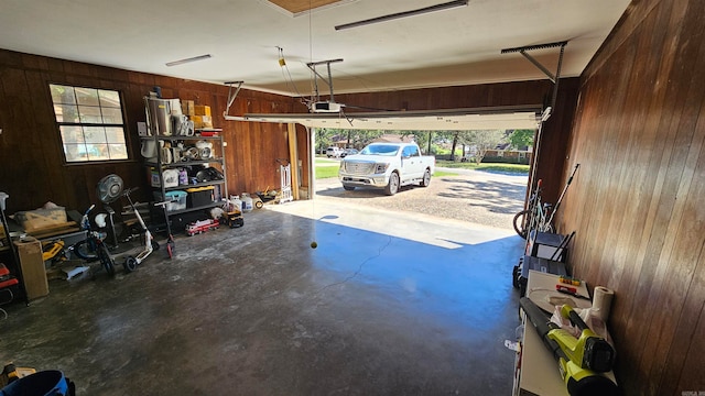 garage with a garage door opener and wooden walls