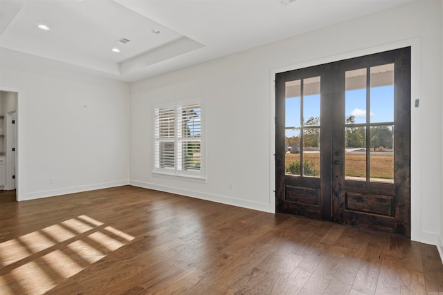 spare room with dark hardwood / wood-style floors, a wealth of natural light, and french doors