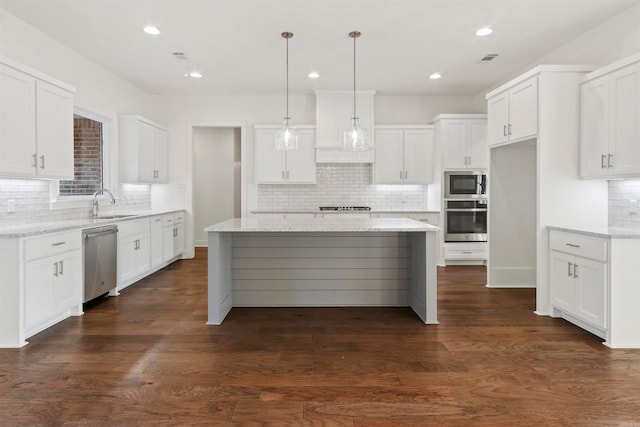 kitchen featuring a kitchen island, white cabinets, dark hardwood / wood-style floors, and appliances with stainless steel finishes