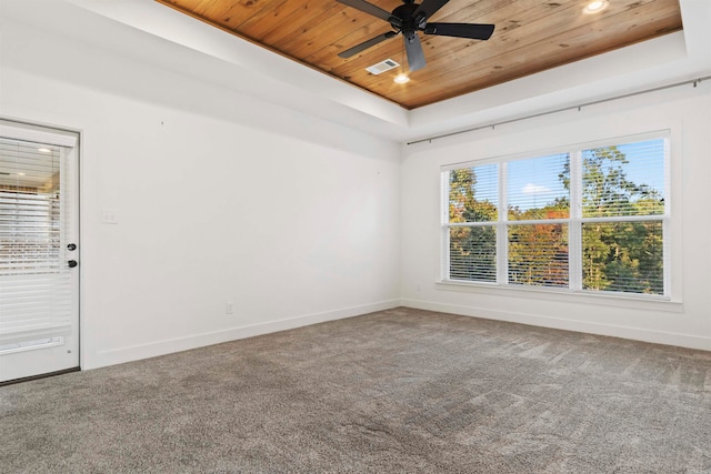 empty room with plenty of natural light, wooden ceiling, and a tray ceiling