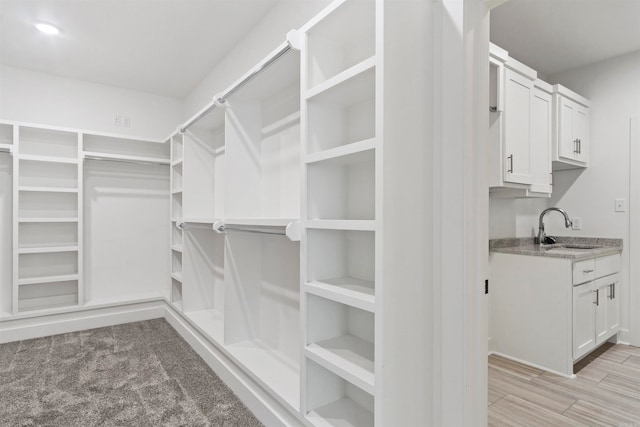 walk in closet featuring light hardwood / wood-style floors and sink