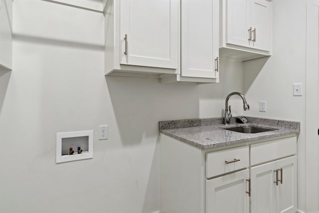 clothes washing area featuring cabinets, washer hookup, and sink