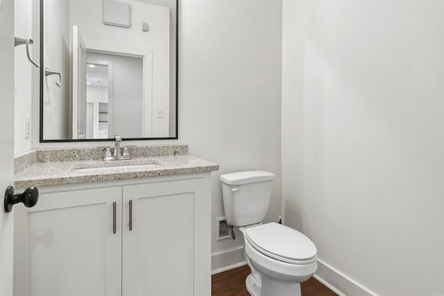 bathroom featuring hardwood / wood-style floors, vanity, and toilet