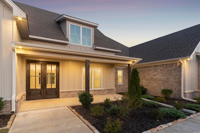 exterior entry at dusk featuring french doors