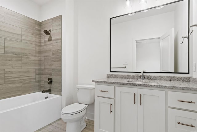 full bathroom featuring vanity, toilet, wood-type flooring, and tiled shower / bath combo