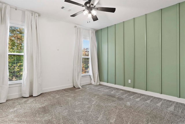 carpeted spare room with plenty of natural light and ceiling fan