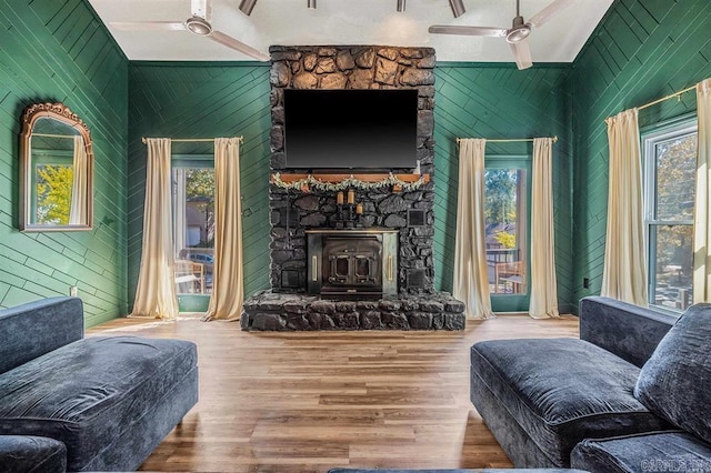 living room featuring a wood stove, a wealth of natural light, and high vaulted ceiling