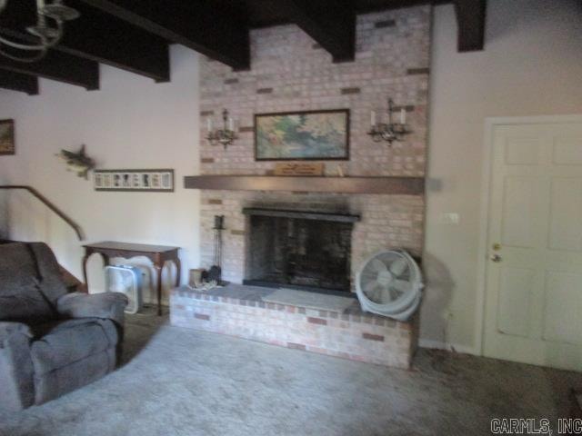 carpeted living room featuring beam ceiling and a brick fireplace