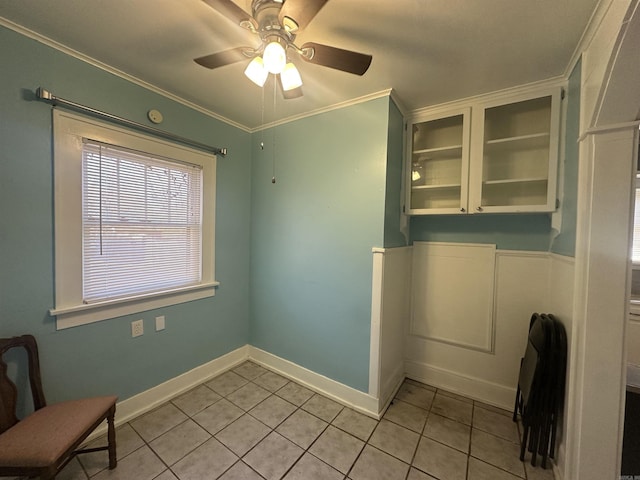 interior space featuring ceiling fan, crown molding, and light tile patterned floors