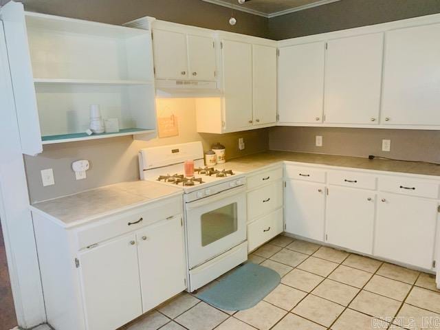 kitchen with white cabinets, white range with gas stovetop, and light tile patterned floors