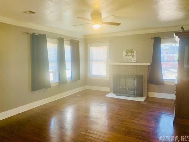 unfurnished living room with a fireplace, wood-type flooring, plenty of natural light, and ornamental molding