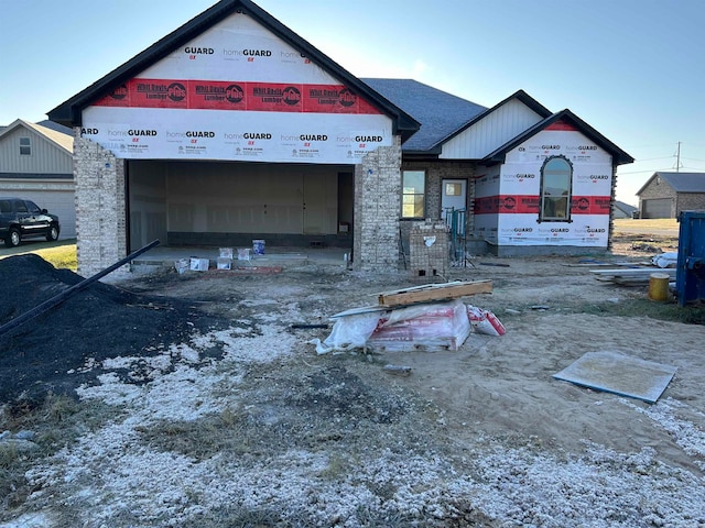 property in mid-construction with driveway and brick siding