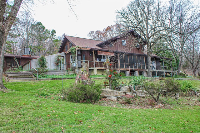 back of property featuring a sunroom and a yard