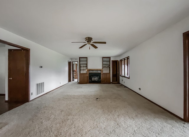 unfurnished living room featuring carpet flooring and ceiling fan