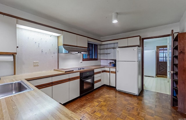 kitchen with dark parquet flooring, sink, white cabinetry, and black appliances