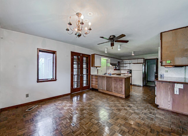 kitchen featuring dark parquet flooring, sink, white refrigerator, kitchen peninsula, and ceiling fan with notable chandelier