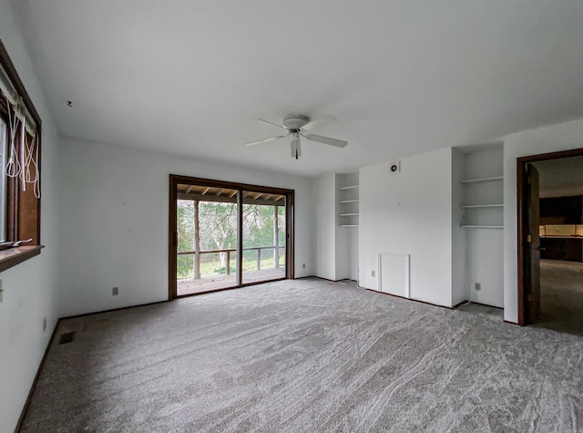 interior space featuring light carpet, built in features, and ceiling fan