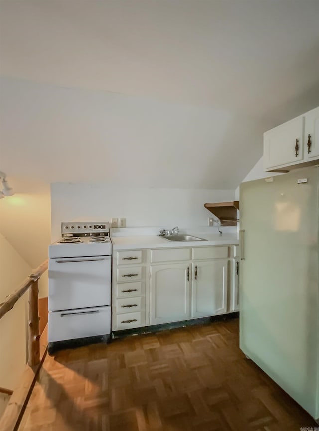 kitchen with dark parquet flooring, sink, lofted ceiling, white appliances, and white cabinets